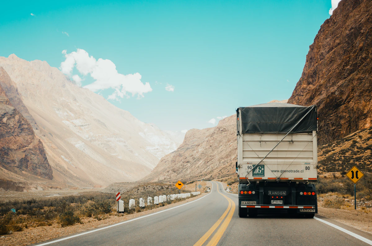 Camionero junto a su camión en un área de descanso de una autopista