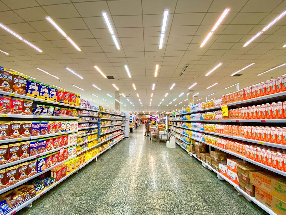 Cajera de supermercado pasando productos por el escáner en la línea de caja